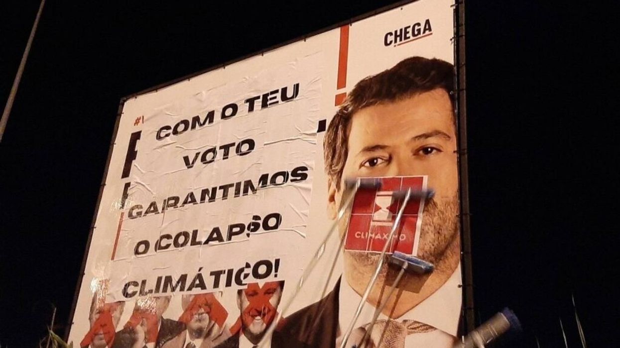 A Portuguese election billboard is modified to read, "With your vote we guarantee climate collapse."