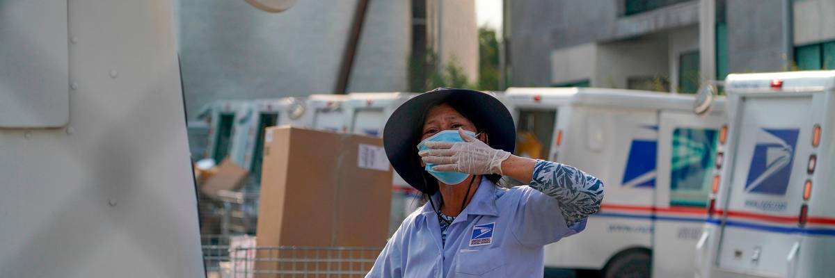 A postal worker blows a kiss to demonstrators