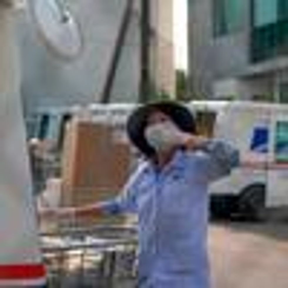 A postal worker blows a kiss to demonstrators