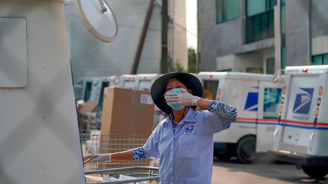 A postal worker blows a kiss to demonstrators