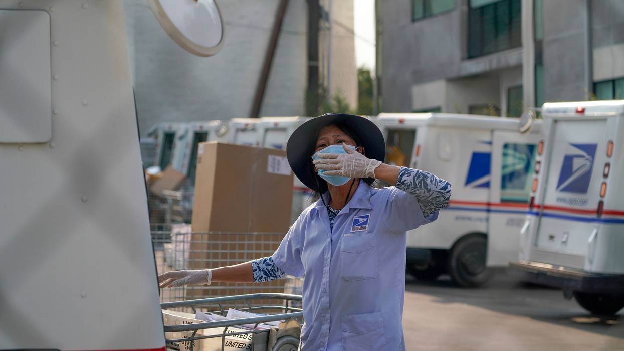 A postal worker blows a kiss.