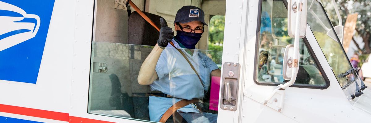 A postal worker gives a thumbs-up to demonstrators protesting the Trump administration's sabotage of the U.S. Postal Service on August 22, 2020 in Los Angeles, California. (Photo: Rich Fury/Getty Images for MoveOn)