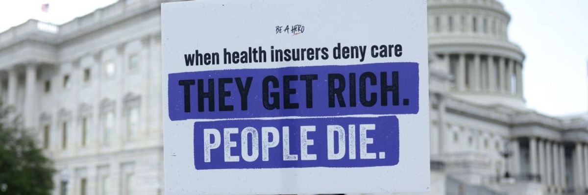 A poster held up against the U.S. Capitol building reading, "When health insurers deny care, they get rich. People die.'