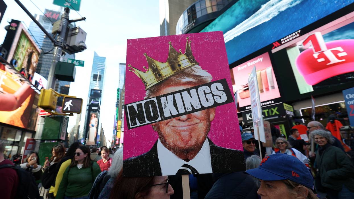 A poster says No Kings over an image of Trump wearing a crown.
