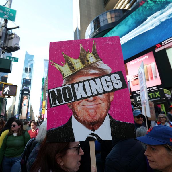 A poster says No Kings over an image of Trump wearing a crown.