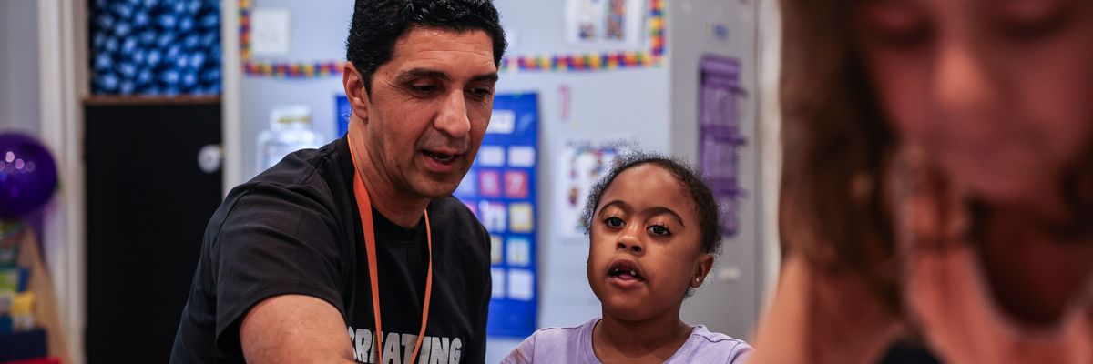 A preschool teacher works with a student