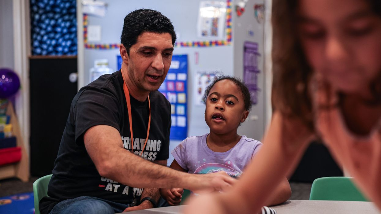A preschool teacher works with a student
