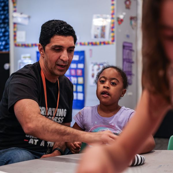 A preschool teacher works with a student