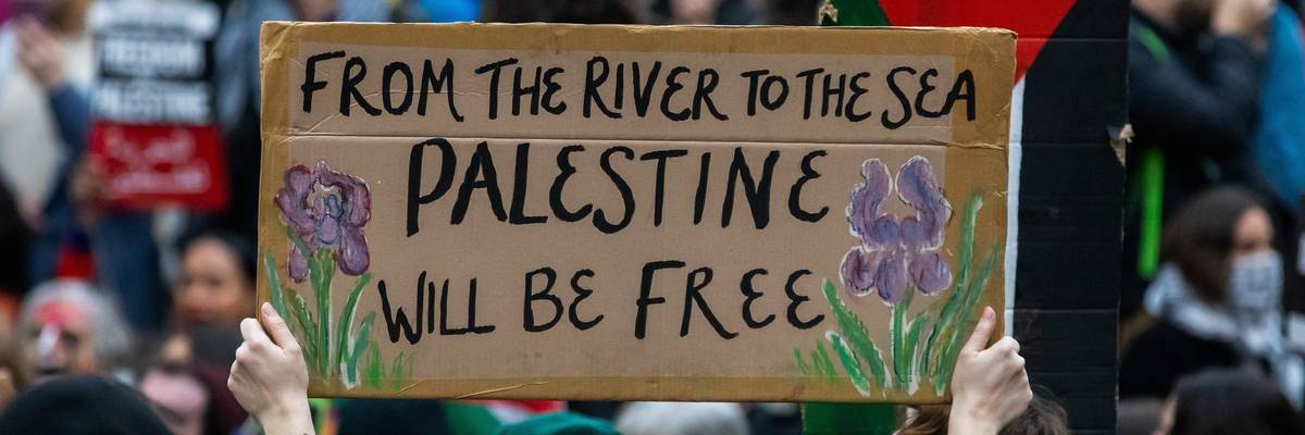 A pro-Palestinian activist holds up a sign reading ‘From The River To The Sea, Palestine Will Be Free.