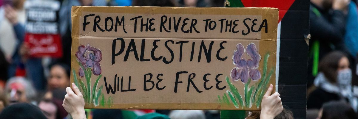 A pro-Palestinian activist holds up a sign reading ‘From The River To The Sea, Palestine Will Be Free.