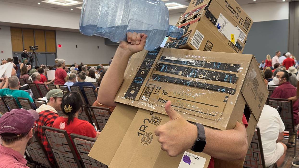 A protester dressed as a data center chugs water.