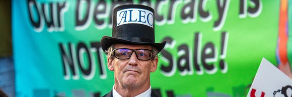 A protester dressed as the manifestation of ALEC.