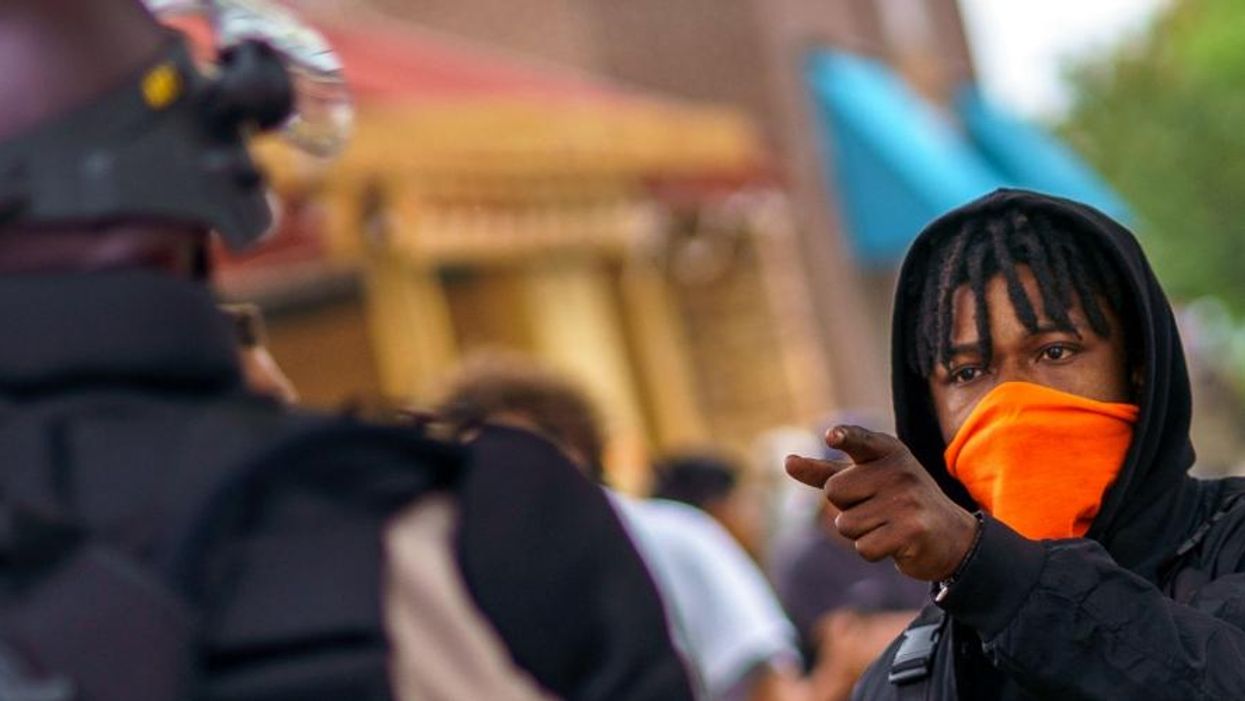 A protester faces off with Minnesota State Police officers on May 29, 2020 in Minneapolis, Minnesota.