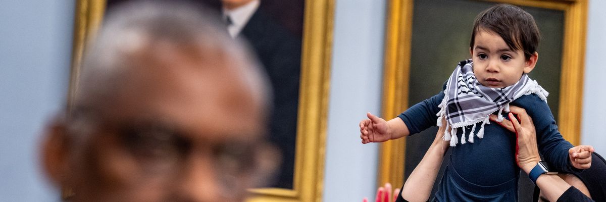 A protester from the group Code Pink holds up a child