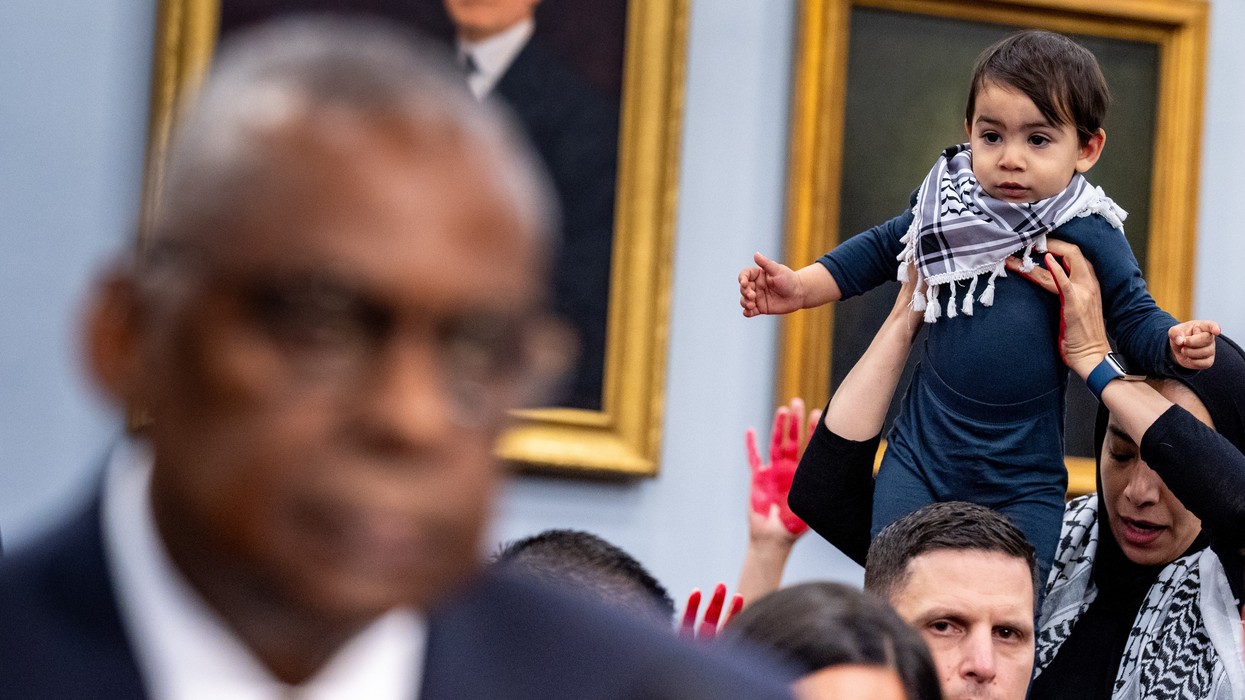 A protester from the group Code Pink holds up a child