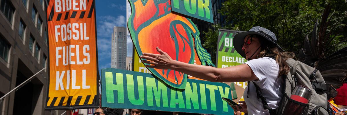 A protester gestures at a sign reading, "For humanity."