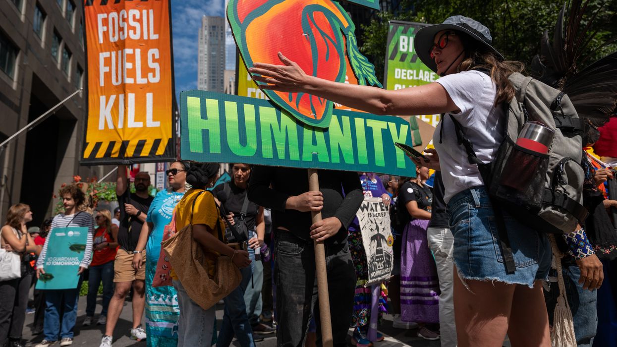A protester gestures at a sign reading, "For humanity."