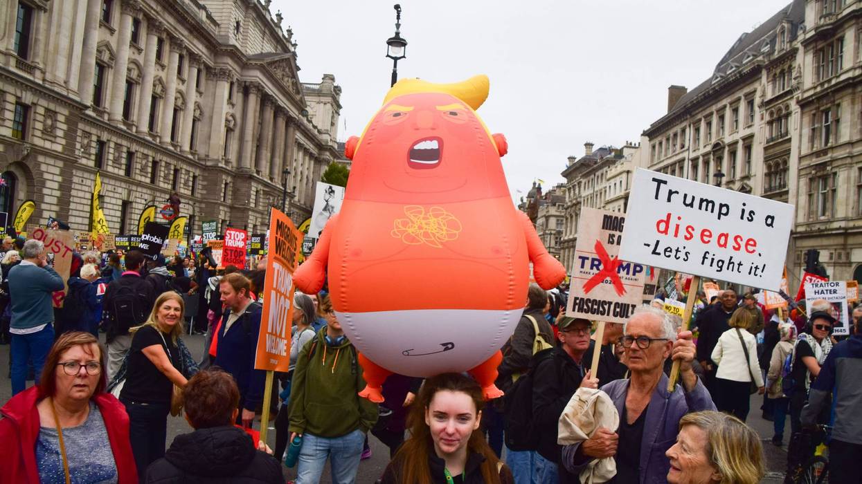 A protester holds a Baby Trump balloon during the