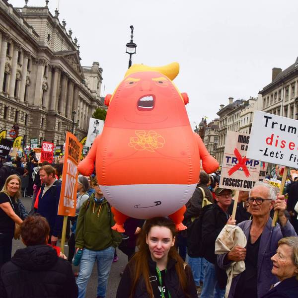 A protester holds a Baby Trump balloon during the