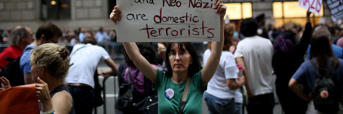 A protester holds a banner reading "The KKK and Neo-Nazis Are Domestic Terrorists" during a rally against then-U.S. President Donald Trump on August 14, 2017 in New York City. (Photo: Mohammed Elshamy/Anadolu Agency via Getty Images)