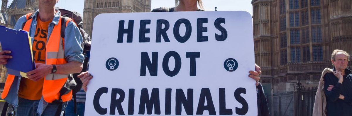 A protester holds a "heroes not criminals" placard