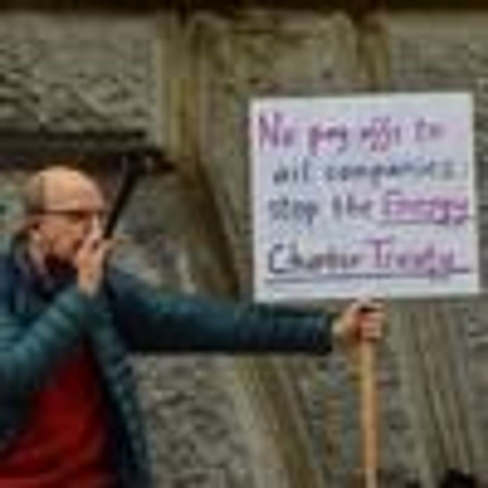 A protester holds a placard calling for the abolition of the Energy Charter Treaty during a Global Day of Action for Climate Justice demonstration in London on November 6, 2021.