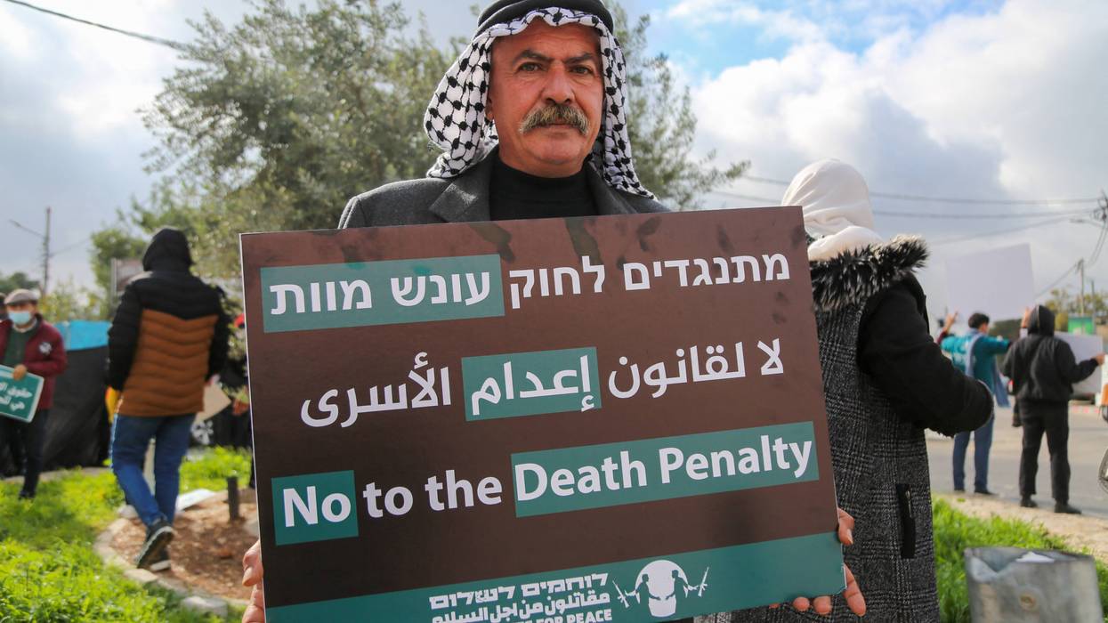 A protester holds a placard reading "No to the Death Penalty"