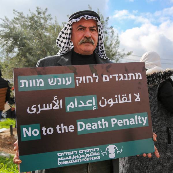 A protester holds a placard reading "No to the Death Penalty"