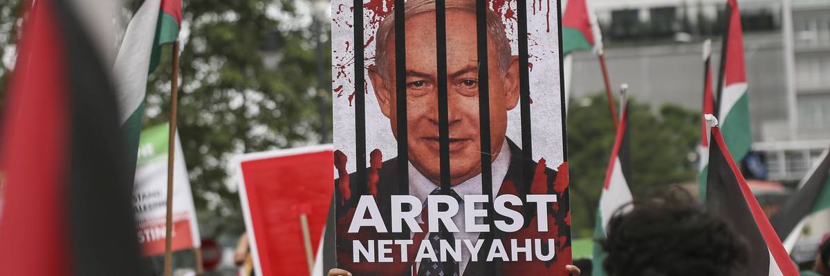 A protester holds a placard saying, "Arrest Netanyahu" during a peaceful solidarity rally