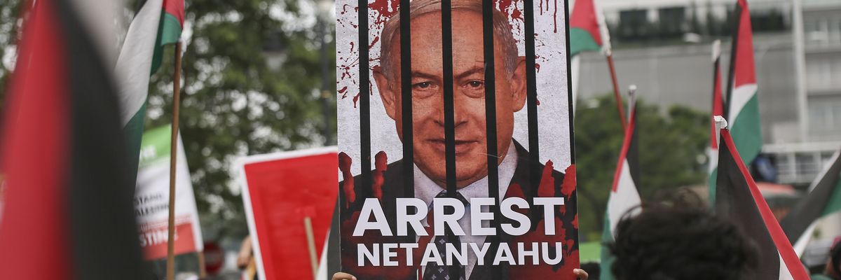A protester holds a placard saying, "Arrest Netanyahu" during a peaceful solidarity rally