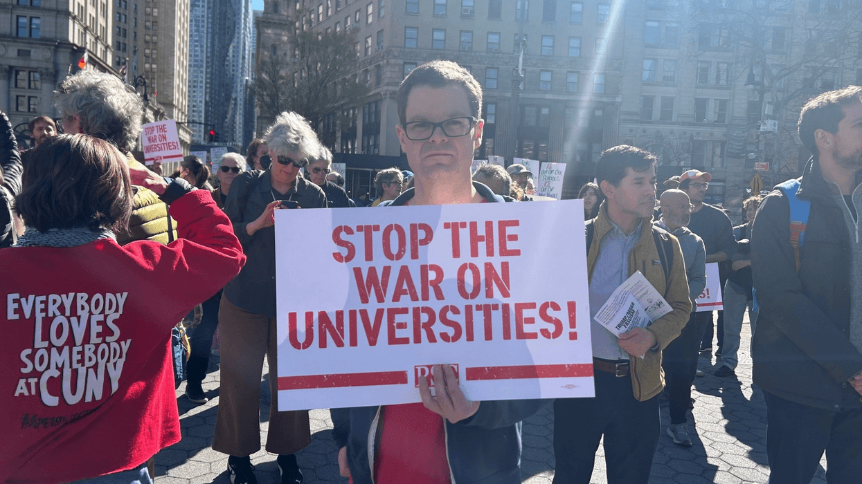 A protester holds a sign reading, "Stop the war on universities"
