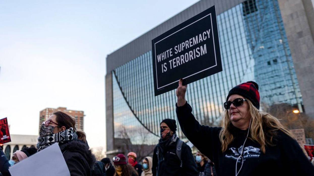 A protester holds a sign reading "White Supremacy is Terrorism"