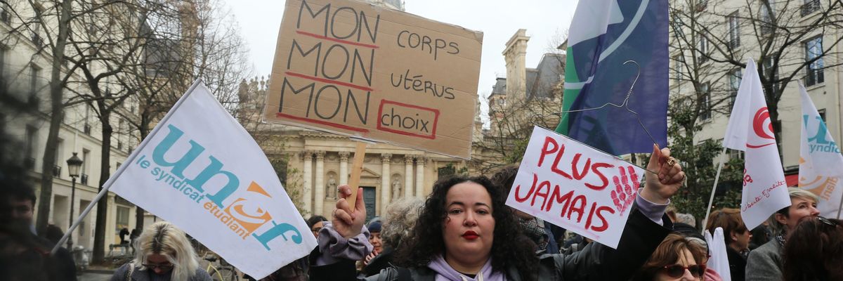 A protester holds a sign that reads ''My body, my uterus, my choice'' in French