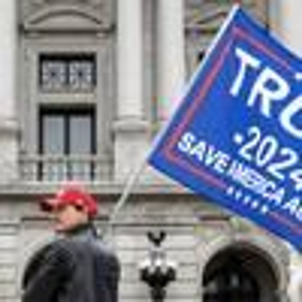 A protester holds a Trump 2024 flag in front of the Pennsylvania State Capitol on February 27, 2021. (Photo: Paul Weaver/SOPA Images/LightRocket via Getty Images)