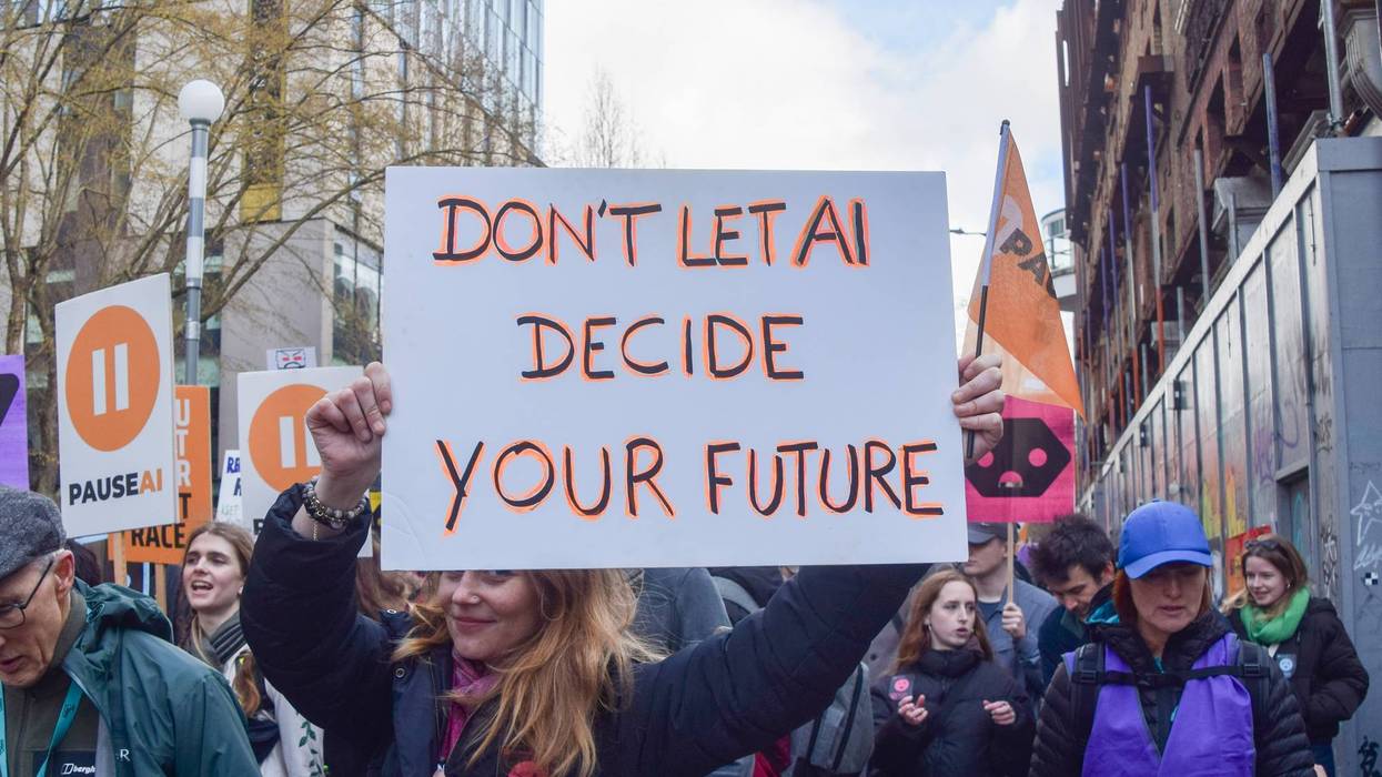 A protester holds an anti-AI placard outside OpenAI offices