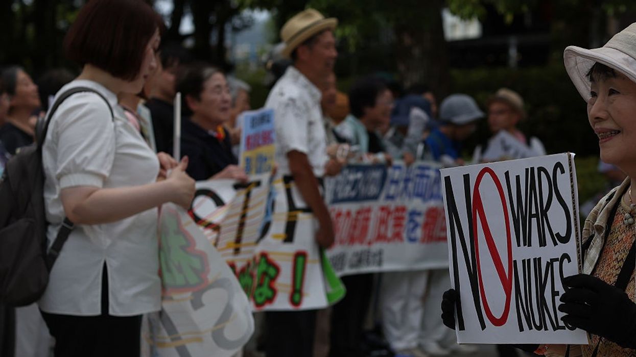 A protester holds an anti-war sign at the Hiroshima Peace Memorial Park