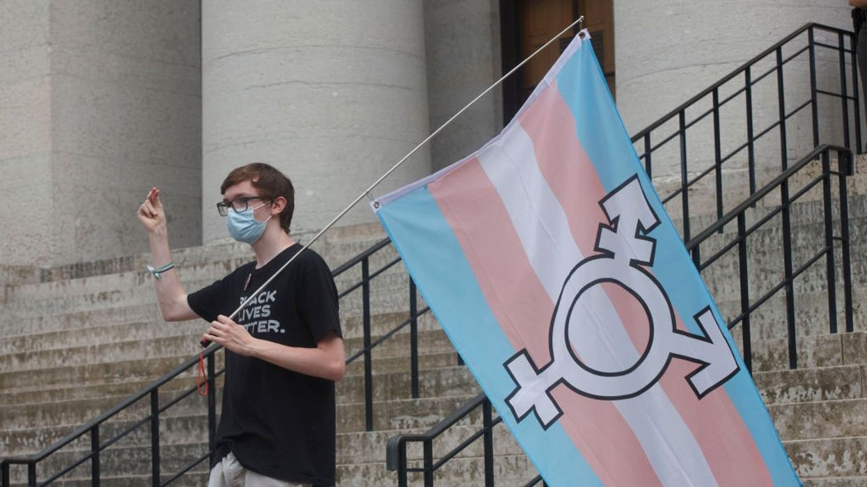 A protester holds the trans flag