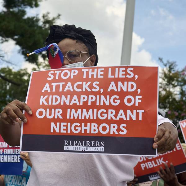 A protester is seen holding a placard