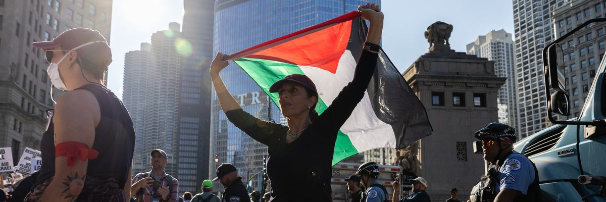 A protester raises a Palestinian flag during a DNC protest