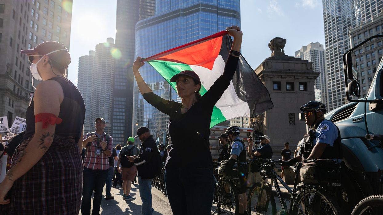 A protester raises a Palestinian flag during a DNC protest