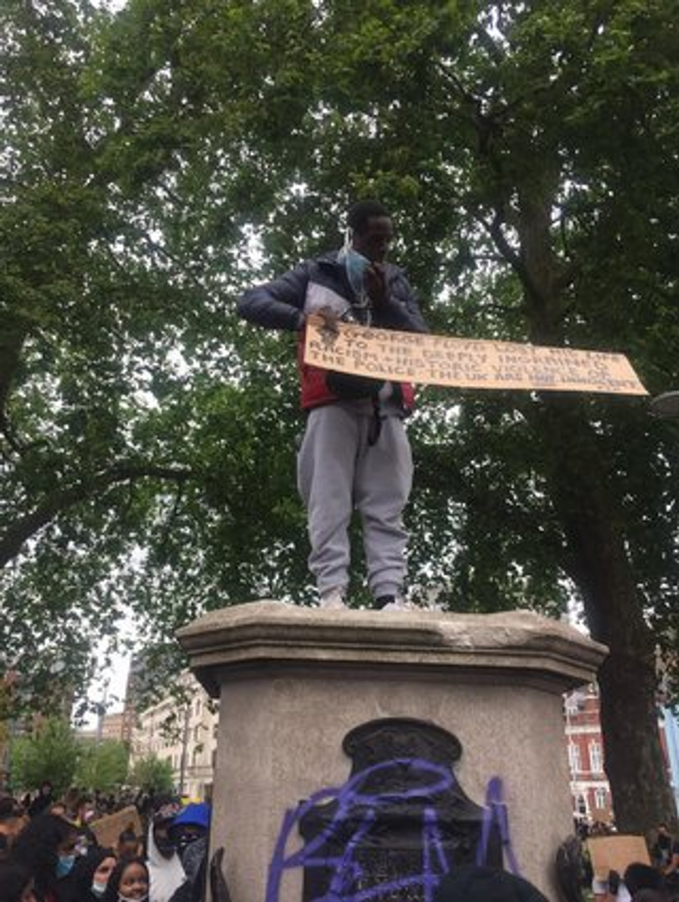 A protester standing on the empty plinth, just vacated by Colston's statue. (Photo: Helen Wilson-Roe)