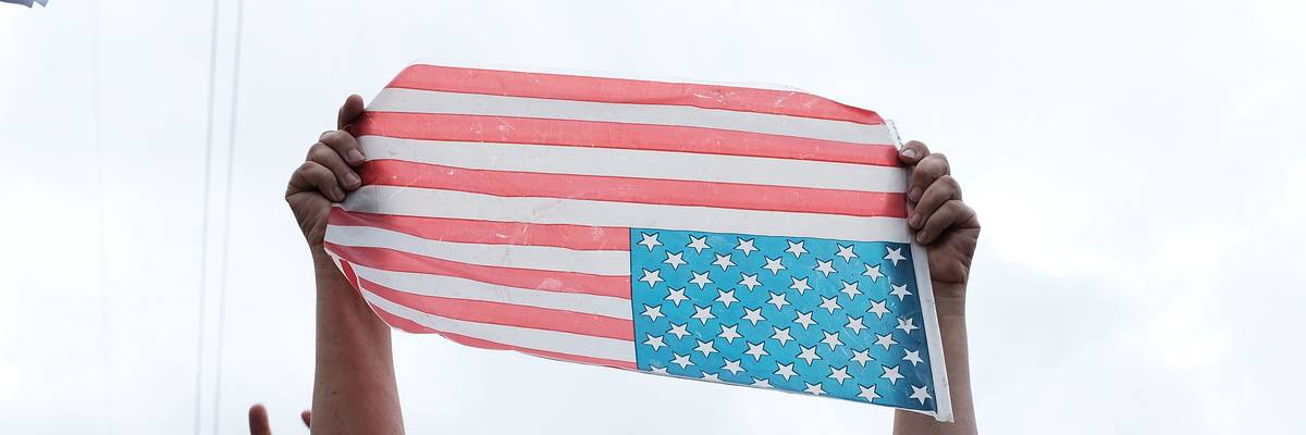 A protester turns an American flag upside down.