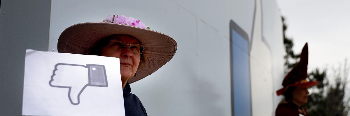 A protester with "Raging Grannies" holds a sign