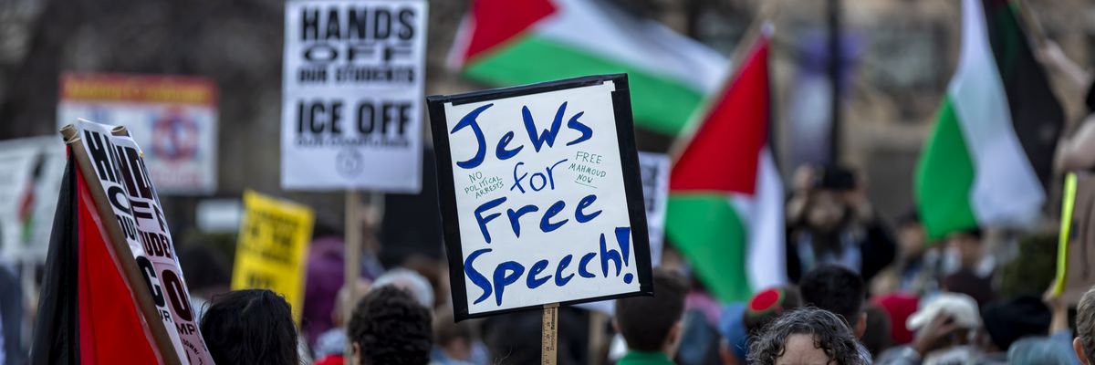 A protestor holds a sign that reads, "Jews for Free Speech"