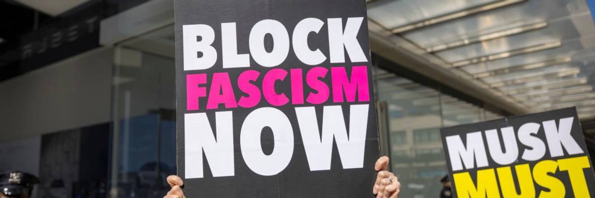 A protestor outside a Tesla showroom in Manhattan holds a...