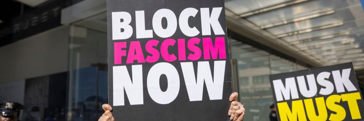 A protestor outside a Tesla showroom in Manhattan holds a...
