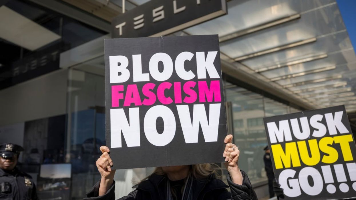 A protestor outside a Tesla showroom in Manhattan holds a...