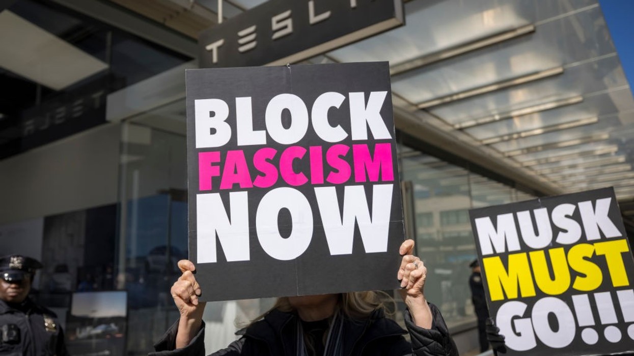 A protestor outside a Tesla showroom in Manhattan holds a...