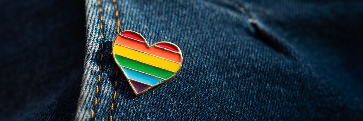 A rainbow LGBTQ heart pin on jeans.