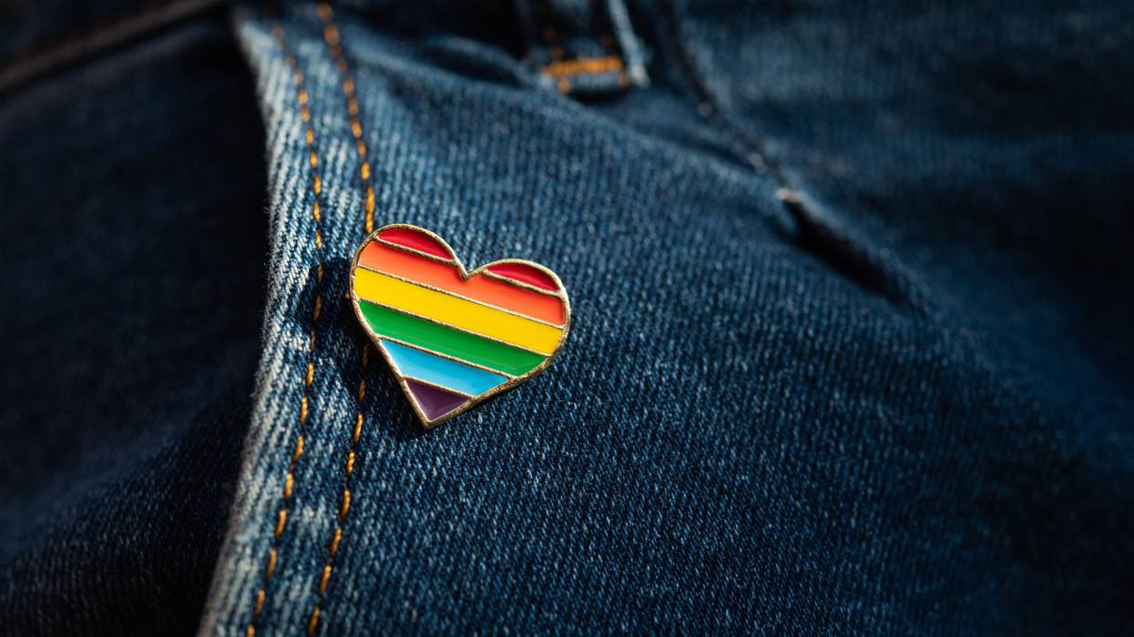 A rainbow LGBTQ heart pin on jeans.
